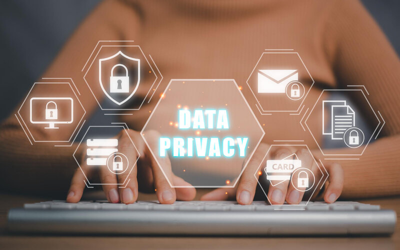 Data privacy protection hologram icons over hands typing on keyboard