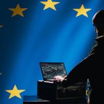 EU flag with person working on laptop